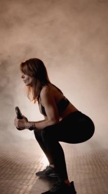 Kettlebell sağlık ve zindelik eğitimi alıyor. Spor salonunda çalışan bir kadın fiziksel sağlığını korumak ve kas gücünü arttırmak için kettlebell egzersizleri yapıyor. Yüksek kalite 4k görüntü