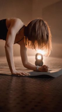 Hedefine odaklanan sporcu, kaslı vücudu güçlendirmek ve esnekliğini korumak üzerine inşa edilmiş ağır egzersizler yapıyor. Karanlık bir spor salonunda aktif tahta egzersizi. Yüksek kalite 4k görüntü