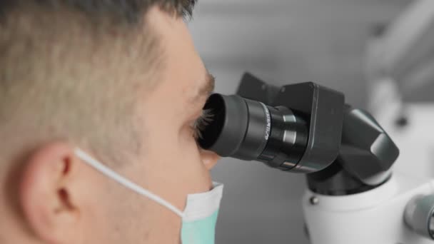歯科医は 正確で信頼できる歯科手順を実行するために歯科顕微鏡を使用し 顕微鏡で自分自身を助け 正確な処理と歯科インプラントの配置を行います 高品質4Kについて — ストック動画