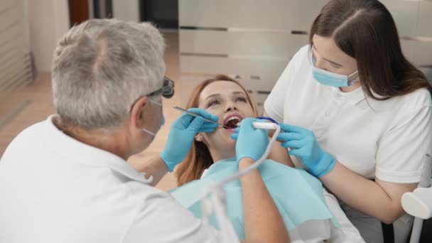 Tandläkaren Och Hans Assistent Arbetar Harmoniskt Tandstolen Ger Patienten Hög — Stockvideo
