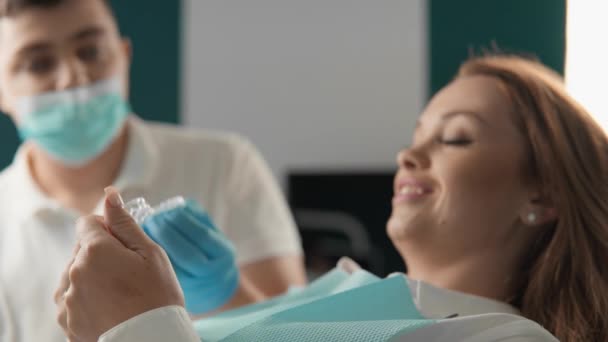 Οδοντίατρος Επιδεικνύει Οδοντοστοιχίες Στον Ασθενή Εξηγώντας Δομή Και Την Τεχνολογία — Αρχείο Βίντεο