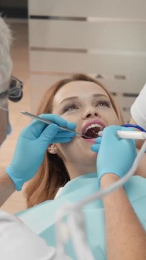 Diş hekimi ve asistanı dişçi koltuğunda uyum içinde çalışarak hastaya yüksek kaliteli ve acısız diş tedavisi sağlıyorlar. Yüksek kalite 4k görüntü
