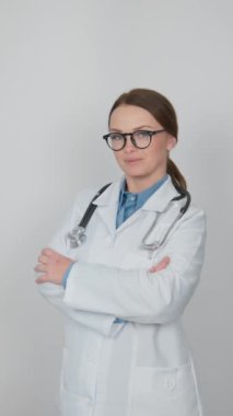 Bu videoda, ofisindeki bir doktor objektifin önünde nazikçe poz veriyor, dost canlısı ve profesyonel bir ruh hali sergiliyor. Dostça görünüşü ve kendine güveni açıklığını gösteriyor.