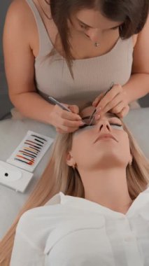 Kirpik uzantılarının her ayrıntısında mükemmelliği vurgula. Video, usta çalışmalarının kusursuz bir sonuca götüren ince yönlerini vurgulamayı başarıyor. Kameranın yukarıdan aşağı görüntüsü. Yüksek