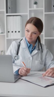 Doktor, bir bilgisayar ekranında yapılan tıbbi muayenelerin sonuçlarını analiz etmeye ve hastalar için etkili tedavi yöntemleri geliştirmeye odaklanıyor. Tıpta uzman biri.