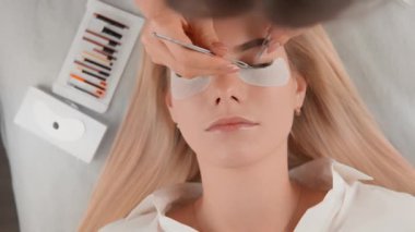 Müşteri güzellik salonundaysa ve uzman kendini sanatına adamışsa, kirpiklerini dikkatlice uzatarak ona zarif ve çekici bir görünüm kazandırır. Yüksek kalite 4k
