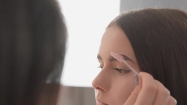 Güzel bir kız kaş modelliği için bir güzellik uzmanından hizmet alır, doğal güzelliğini ve gözlerinin ifade ediciliğini vurgular. Bir güzellik salonunu ziyaret eden müşteri,