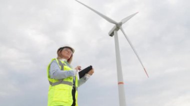 Dijital tabletli bir mühendis, modern dünyanın ve çevresel gereksinimleri dikkate alarak rüzgar enerjisinin kullanımını optimize etmek için yenilikçi çözümler geliştirir. Yüksek kalite 4k