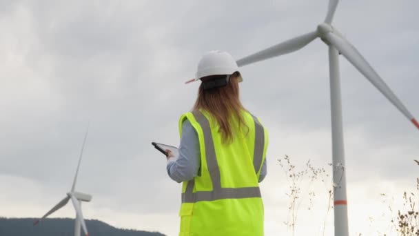 Contexto Las Majestuosas Turbinas Eólicas Mujer Desarrolla Una Estrategia Para — Vídeos de Stock