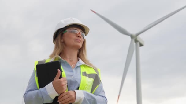 デジタルタブレットを持つ女性エンジニアは 風力エネルギーのデータを分析し 風力を利用して安定した持続可能なエネルギー源を作り出す可能性を探ります 高品質の4K映像 — ストック動画