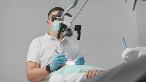 歯の抽出手順の間に 医師は周囲のティッシュを損傷することなく歯の根部を正確に切断し 除去するために顕微鏡を使用します 高品質の4K映像 — ストック動画