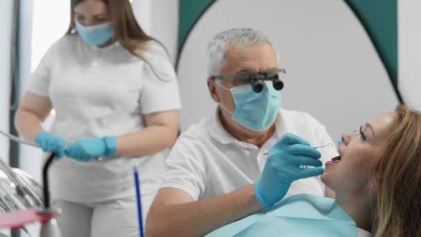 歯科医と彼のアシスタントは 治療プロセスのすべての詳細に注意を払い 患者に高いレベルの専門的なケアとサポートを提供します 高品質の4K映像 — ストック動画