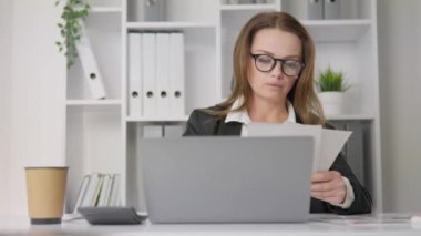 Bir kadın girişimci finansal sorunları çözer ve işini geliştirir. Bir iş analisti belgeleri inceler ve kârlılığı artırmak için stratejiler geliştirir. Yüksek kalite 4k görüntü