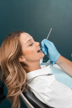 Doktor dişlerin durumunu dikkatli bir gözle inceliyor gibi yapar ve en doğru teşhis için modern teknolojileri kullanır. Yüksek hassasiyet ve bilgiyle, doktor