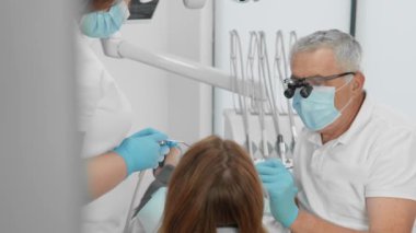 Diş hekimi ve asistanı, dişçi koltuğundaki diş tedavisi sırasında hastaya tam kapsamlı profesyonel hizmetler ve ilgi sağlayarak uyumlu bir şekilde işbirliği yaparlar. Yüksek kalite 4k