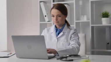 Bir tıp uzmanı sistematik olarak tıbbi kayıtlara girer ve doğru teşhis ve tedavi için hasta verilerini analiz eder. Klinikte bilgisayarla çalışan bir doktor. Yüksek kalite 4k