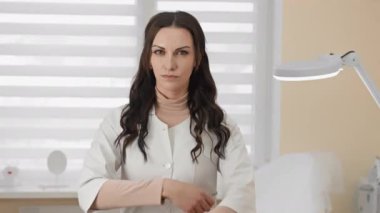 Kendine güvenen bir kadın doktor modern bir klinikte profesyonelliğini ve bağlılığını sergiliyor. Beyaz önlük giyiyor, iyi donanımlı bir sağlık merkezinde tıbbi bakım sağlamaya hazır..