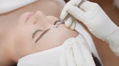 Profesyonel bir kozmetolog özel aletler kullanarak yüz çıkarma prosedürü uygular. Hasta rahatlamış, yüz görünümünü ve sağlığını iyileştirmek için uzman cilt bakımı alıyor..