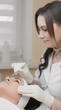 Modern bir kuaförde, bir güzellik uzmanı titizlikle bir müşteriye kirpik eklemeler yapar. Detaylara ve ustalıkla çok dikkat eder.