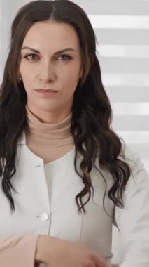 Kendine güvenen bir kadın doktor modern bir klinikte profesyonelliğini ve bağlılığını sergiliyor. Beyaz önlük giyiyor, iyi donanımlı bir sağlık merkezinde tıbbi bakım sağlamaya hazır..