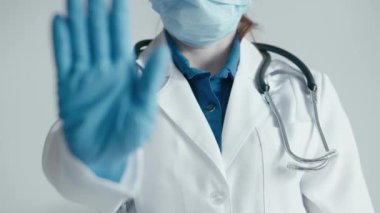 Laboratuvar önlüğü, steteskop, eldiven ve maske de dahil olmak üzere koruyucu giysiler içinde sağlık görevlisi. Tıbbi ortamlarda güvenlik, ihtiyat ve önleyici tedbirler kavramı.