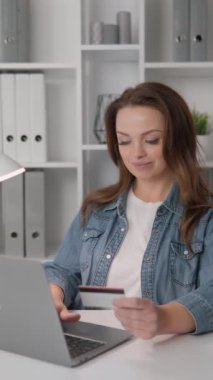 Müşteri elektronik finans hizmetlerinden kolayca faydalanıyor ve internet üzerinden işlemlerin kolaylığını ve güvenliğini sağlıyor. Kadının keyfi yerindeyken internetten alışveriş yapıyor.