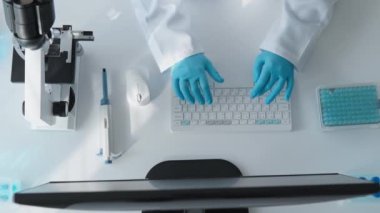 Tıp laboratuarında, bir genetikçi bir bilgisayarda çalışır, genetik mutasyonlar üzerinde yüksek hassasiyetli çalışmalar yapar ve umut verici tedavi yöntemleri geliştirir. Mikroskop altında DNA üzerinde çalışıyor.
