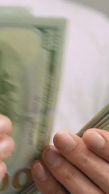 Bir kişinin iki eliyle bir yığın banknotu saymasını gösteren yakın çekim videoları. Görüntüler serisi paranın ele alınması ve düzenlenmesine, mali ve ekonomik temaların vurgulanmasına odaklanıyor.