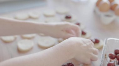 Zanaatkar, hamur turtalarına taze kirazları özenle ve titizlikle hazırlıyor. Mutfak işçiliğini ön plana çıkarıyor.