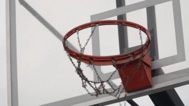 Bir basketbol topunun sokak sahasında pota vuruşunu gösteren yakın plan bir fotoğraf spor illüstrasyonları ve eğitim materyalleri, hareketlilik ve açık havada oynamak için mükemmeldir.