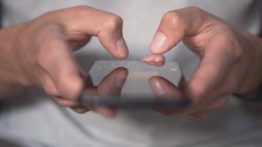 Çevrimiçi ödemelerin ve mobil bankacılığın modern kolaylığını gösteren akıllı telefon ve kredi kartı tutan ellerin yakın plan görüntüsü. Güvenli e-ticaret ve mali işlemler.