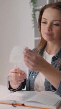 Bir kadın, muhasebe, bankacılık ve mali değerlendirme için muhasebe, bütçe ve mali planlama, düzgün para yönetimi sağlama üzerine odaklanarak, makbuzları evde sınıflandırıyor