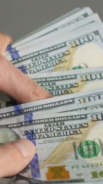 Bu resim birkaç yüz dolarlık banknotları tutan ellerin yakın çekimini gösteriyor. Bu da bizi hayatımızdaki nakit paranın önemini ve günlük deneyimlerimizde uyandırdığı duyguları keşfetmeye itiyor.