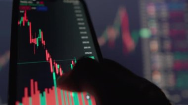 Dinamik görüntüler akıllı telefon ekranında canlı şamdan çizelgeleri sergiliyor parmaklar arasında borsa analizini yürütüyor. Finans, ticaret ve yatırım görselleri için mükemmel.