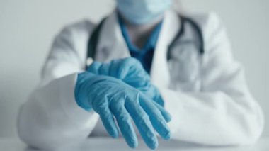 Mavi eldiven ve laboratuvar önlüğü giyen bir sağlık uzmanının odaklanmış bir görüntüde prosedüre hazırlandığı görülüyor. Sağlık ve profesyonellikle ilgili konular için uygundur
