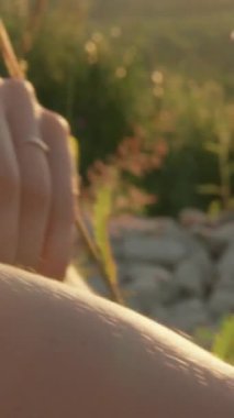 Kadın, gün batımının sıcacık ışığında papatyalarla çevrili. Doğasında huzur ve neşe yayıyor. Huzurlu manzaranın tadını çıkarıyor. Huzurlu ve huzurlu hissediyor.