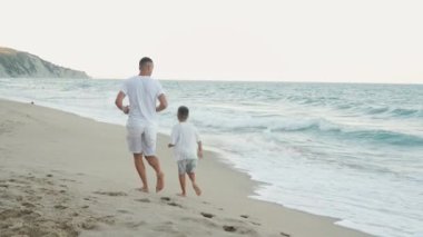 Bir baba ve oğul kıyı şeridinde el ele yürür, tatillerinin tadını çıkarırlar. Bu sahne onların güçlü bağlarını ve paylaştıkları rahatlığı sembolize ediyor. Hayatları boyunca hatırlayacakları anılar yaratıyorlar.