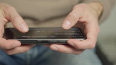Yakın çekimde akıllı telefonla el ele tutuşurken görülüyor. Kişi ya dokunmatik ekran ve el hareketlerine odaklanmış bir uygulama üzerinden mesajlaşıyor, kayıyor ya da geziniyor.