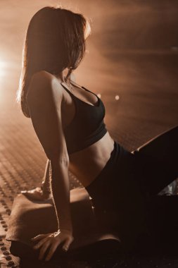 Canlı bir atmosferde, modern fitness kıyafeti içindeki kendine güvenen bir kadın, güç ve zarafeti temsil eder, sağlık ve refahı diğerleri için ilham verici bütünsel bir yaşam tarzı olarak somutlaştırır.