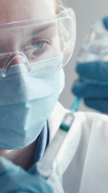 Koruyucu ekipmanlı bir sağlık çalışanı aşı enjeksiyonu hazırlıyor, sağlık, tıbbi içerik, aşı kampanyaları ve laboratuvar ayarları için uygun. Anahtar sözcükler antiviral, biyomedikal, biyoteknoloji, bakım