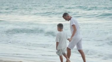 Sevgi dolu bir baba, güzel sahil boyunca genç oğluyla el ele yürürken deniz kenarında değerli anların tadını çıkarırken sonsuza dek kalplerinde kalacak unutulmaz anılar yaratıyor.