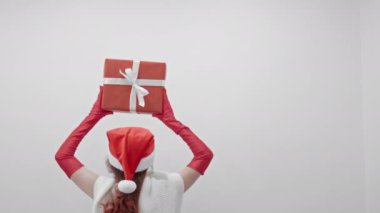 Bu festival görüntüsü Noel ve Yeni Yıl 'ın ruhunu yansıtıyor, parlak hediyeler arasında neşeli bir figür, sıcaklık ve bayram neşesi yayıyor, mutluluk ve beraberliği çağrıştırıyor.