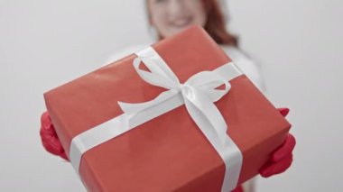 Neşeli bir sahne, Noel 'in özünü yakalar, gülümseyen bir insanın elinde paketlenmiş bir hediyeyle. Bu harika tatil sezonunda kutlanan bu büyülü ruhu kucaklayın.