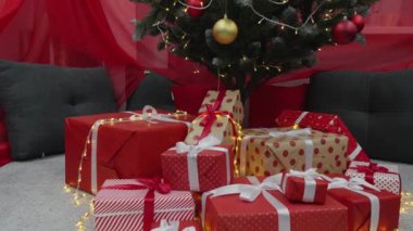 Güzel dekore edilmiş bir ağacın altında, göz kamaştırıcı kırmızı ve parlak Noel hediyeleri, Noel ruhunu kutlamak ve yeni yılı sevdiklerimizle karşılamak için mükemmel.
