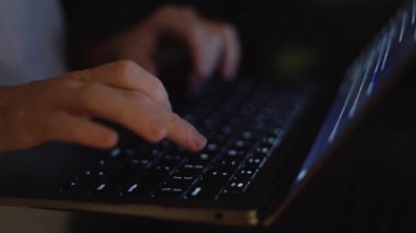 Yakından bakınca, dizüstü bilgisayarda koyu bir arka planda el yazısıyla yazı yazdığını görüyoruz. Parlayan anahtarlar çevreyi aydınlatır, üretkenliği ve gelişen teknoloji dünyasını sembolize eder.