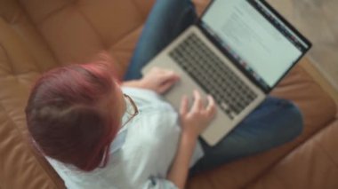 Genel bakış, rahat bir koltukta rahat bir şekilde otururken, rahat ve yaratıcı bir ortamda üretkenlikle uzaktan çalışmanın özünü somutlaştıran bir insanın dizüstü bilgisayarına odaklandığını gösteriyor.