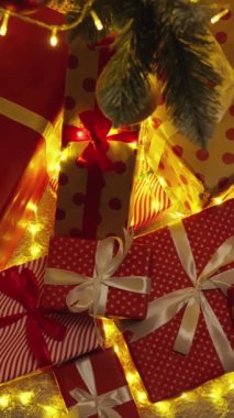 Parlak kurdelelerle süslenmiş renkli Noel hediyelerinin ışıldayan ışıklarla parıldayan muhteşem bir ağacın altına yerleştirilmiş neşeli tatil ruhunun gerçek özünü yansıtan canlı bir sahne.