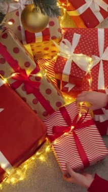 Sarılı kırmızı hediyeler, parlak kurdeleler ve parıldayan ışıklarla dolu canlı bir sahne hayal edin. Bu sezonun neşeli ruhunu ve beraberliğini kutlayan sıcak bir Noel atmosferi yaratıyor.