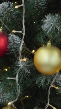 Şenlikli bir Noel ağacı, parlak kırmızı ve altın süslerle süslenmiş, parlak ışıklar ve neşeli sezonu kutlamak için mükemmel bir ren geyiği süslemesi ile odada dimdik duruyor.