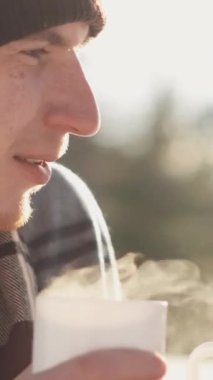 Neşeli bir çift kış pikniğinin tadını çıkarıyor, karlı havada sıcak içecekler yudumluyor. Birlikte neşeli anılar yaratmak için büyülü bir kış kaçamağı arayan aşıklar için mükemmeldir.